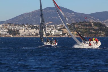 Bodrum, Hindi. 09 Şubat 2020: Ege Denizi 'nin mavi sularında, ünlü tatil beldesi Bodrum' un kıyılarında yelkenliler rüzgarlı havada yelken açıyor.