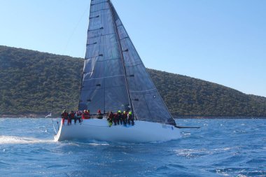 Bodrum, Hindi. 09 Şubat 2020: Ege Denizi 'nin mavi sularında, ünlü tatil beldesi Bodrum' un kıyılarında yelkenliler rüzgarlı havada yelken açıyor.