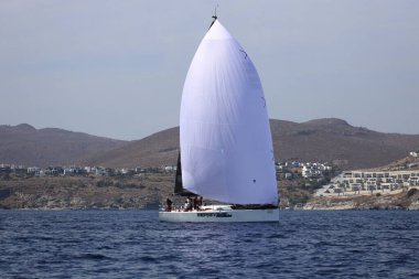 Bodrum, Hindi. 07 Ekim 2023: Ege Denizi 'nin mavi sularında, ünlü tatil beldesi Bodrum' un kıyılarında yelkenliler rüzgarlı havada yelken açıyor.