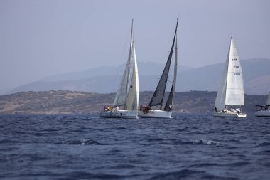 Bodrum, Hindi. 07 Ekim 2023: Ege Denizi 'nin mavi sularında, ünlü tatil beldesi Bodrum' un kıyılarında yelkenliler rüzgarlı havada yelken açıyor.
