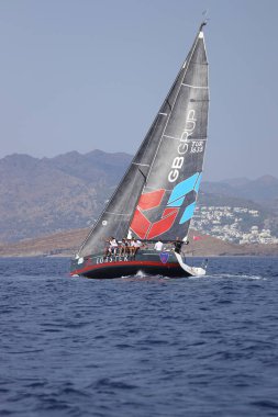 Bodrum, Hindi. 07 Ekim 2023: Ege Denizi 'nin mavi sularında, ünlü tatil beldesi Bodrum' un kıyılarında yelkenliler rüzgarlı havada yelken açıyor.