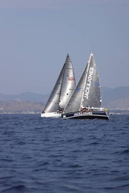 Bodrum, Hindi. 07 Ekim 2023: Ege Denizi 'nin mavi sularında, ünlü tatil beldesi Bodrum' un kıyılarında yelkenliler rüzgarlı havada yelken açıyor.