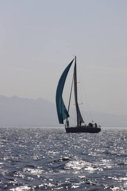 Bodrum, Hindi. 07 Ekim 2023: Ege Denizi 'nin mavi sularında, ünlü tatil beldesi Bodrum' un kıyılarında yelkenliler rüzgarlı havada yelken açıyor.