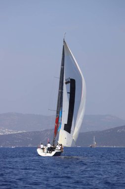 Bodrum, Hindi. 07 Ekim 2023: Ege Denizi 'nin mavi sularında, ünlü tatil beldesi Bodrum' un kıyılarında yelkenliler rüzgarlı havada yelken açıyor.