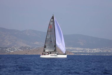 Bodrum, Hindi. 07 Ekim 2023: Ege Denizi 'nin mavi sularında, ünlü tatil beldesi Bodrum' un kıyılarında yelkenliler rüzgarlı havada yelken açıyor.