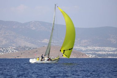 Bodrum, Hindi. 07 Ekim 2023: Ege Denizi 'nin mavi sularında, ünlü tatil beldesi Bodrum' un kıyılarında yelkenliler rüzgarlı havada yelken açıyor.