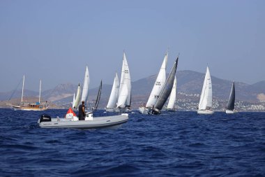 Bodrum, Hindi. 08 Ekim 2023: Yelkenliler Ege Denizi 'nin mavi sularında, ünlü tatil beldesi Bodrum' un kıyılarında rüzgarlı havada yelken açıyorlar..