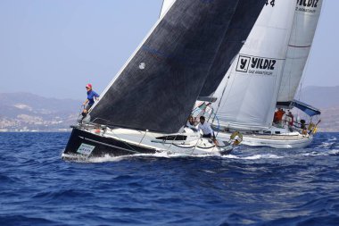 Bodrum, Hindi. 08 Ekim 2023: Yelkenliler Ege Denizi 'nin mavi sularında, ünlü tatil beldesi Bodrum' un kıyılarında rüzgarlı havada yelken açıyorlar..