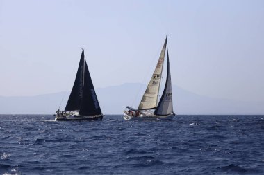 Bodrum, Hindi. 08 Ekim 2023: Yelkenliler Ege Denizi 'nin mavi sularında, ünlü tatil beldesi Bodrum' un kıyılarında rüzgarlı havada yelken açıyorlar..