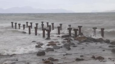 Fırtınalı denizde eski metal iskele parçalanmış.