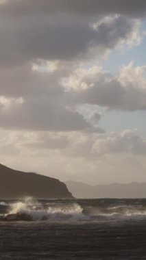 Denizin üzerinde fırtına bulutları. Fırtınadan önce güneş ışığı hareketi. Deniz kenti Turgutreis ve muhteşem gün batımları. Sosyal medya için dikey video.