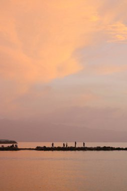 Ünlü tatil beldesi Bodrum 'da turistler gün batımında balık tutarak vakit geçirirler..