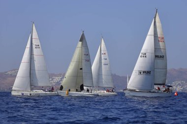 Bodrum, Hindi. 08 Ekim 2023: Yelkenliler Ege Denizi 'nin mavi sularında, ünlü tatil beldesi Bodrum' un kıyılarında rüzgarlı havada yelken açıyorlar..