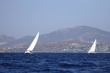 Bodrum, Hindi. 08 Ekim 2023: Yelkenliler Ege Denizi 'nin mavi sularında, ünlü tatil beldesi Bodrum' un kıyılarında rüzgarlı havada yelken açıyorlar..