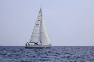 Bodrum, Hindi. 07 Ekim 2023: Ege Denizi 'nin mavi sularında, ünlü tatil beldesi Bodrum' un kıyılarında yelkenliler rüzgarlı havada yelken açıyor.
