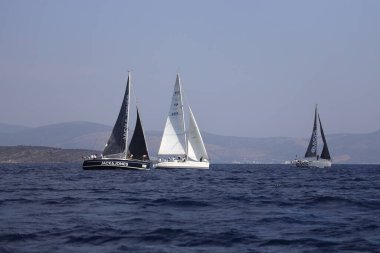 Bodrum, Hindi. 07 Ekim 2023: Ege Denizi 'nin mavi sularında, ünlü tatil beldesi Bodrum' un kıyılarında yelkenliler rüzgarlı havada yelken açıyor.