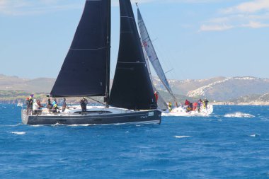 Bodrum, Hindi. 01 Mart 2020: Yelkenliler Ege Denizi 'nin mavi sularında, ünlü tatil beldesi Bodrum' un kıyılarında rüzgarlı havada yelken açıyor..