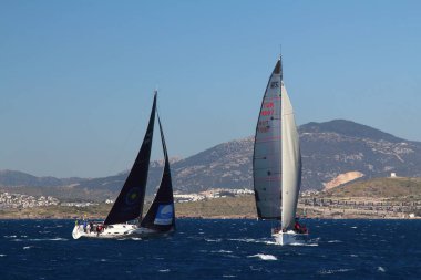 Bodrum, Hindi. 01 Mart 2020: Yelkenliler Ege Denizi 'nin mavi sularında, ünlü tatil beldesi Bodrum' un kıyılarında rüzgarlı havada yelken açıyor..