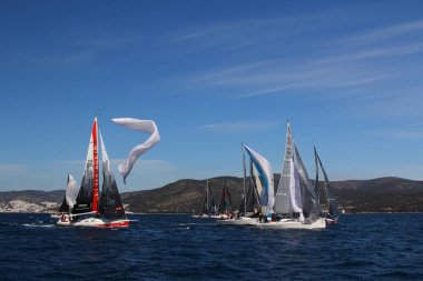 Bodrum, Hindi. 01 Mart 2020: Yelkenliler Ege Denizi 'nin mavi sularında, ünlü tatil beldesi Bodrum' un kıyılarında rüzgarlı havada yelken açıyor..