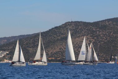 Bodrum, Hindi. 01 Mart 2020: Yelkenliler Ege Denizi 'nin mavi sularında, ünlü tatil beldesi Bodrum' un kıyılarında rüzgarlı havada yelken açıyor..