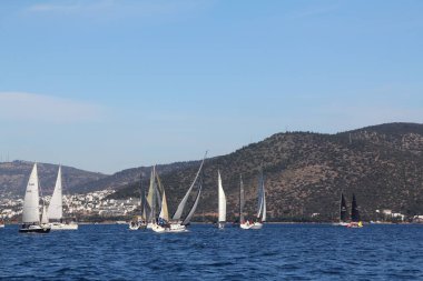 Bodrum, Hindi. 01 Mart 2020: Yelkenliler Ege Denizi 'nin mavi sularında, ünlü tatil beldesi Bodrum' un kıyılarında rüzgarlı havada yelken açıyor..