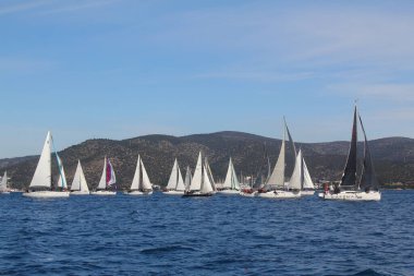 Bodrum, Hindi. 01 Mart 2020: Yelkenliler Ege Denizi 'nin mavi sularında, ünlü tatil beldesi Bodrum' un kıyılarında rüzgarlı havada yelken açıyor..