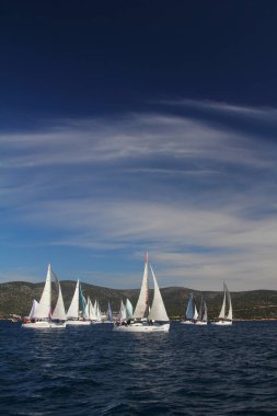 Bodrum, Hindi. 01 Mart 2020: Yelkenliler Ege Denizi 'nin mavi sularında, ünlü tatil beldesi Bodrum' un kıyılarında rüzgarlı havada yelken açıyor..