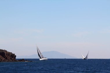 Bodrum, Hindi. 01 Mart 2020: Yelkenliler Ege Denizi 'nin mavi sularında, ünlü tatil beldesi Bodrum' un kıyılarında rüzgarlı havada yelken açıyor..