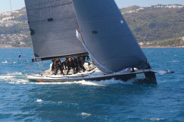 Bodrum, Hindi. 01 Mart 2020: Yelkenliler Ege Denizi 'nin mavi sularında, ünlü tatil beldesi Bodrum' un kıyılarında rüzgarlı havada yelken açıyor..