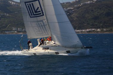 Bodrum, Hindi. 01 Mart 2020: Yelkenliler Ege Denizi 'nin mavi sularında, ünlü tatil beldesi Bodrum' un kıyılarında rüzgarlı havada yelken açıyor..