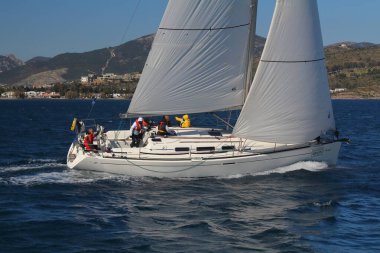 Bodrum, Hindi. 01 Mart 2020: Yelkenliler Ege Denizi 'nin mavi sularında, ünlü tatil beldesi Bodrum' un kıyılarında rüzgarlı havada yelken açıyor..