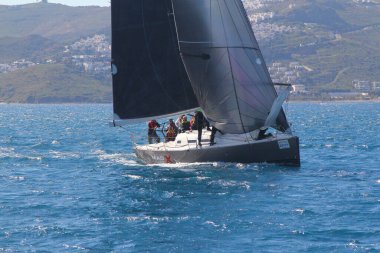 Bodrum, Hindi. 01 Mart 2020: Yelkenliler Ege Denizi 'nin mavi sularında, ünlü tatil beldesi Bodrum' un kıyılarında rüzgarlı havada yelken açıyor..