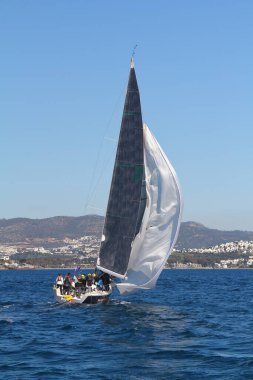 Bodrum, Hindi. 01 Mart 2020: Yelkenliler Ege Denizi 'nin mavi sularında, ünlü tatil beldesi Bodrum' un kıyılarında rüzgarlı havada yelken açıyor..