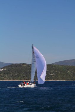 Bodrum, Hindi. 01 Mart 2020: Yelkenliler Ege Denizi 'nin mavi sularında, ünlü tatil beldesi Bodrum' un kıyılarında rüzgarlı havada yelken açıyor..