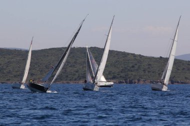 Bodrum, Hindi. 22 Mart 2019: Yelkenliler Ege Denizi 'nin mavi sularında, ünlü tatil beldesi Bodrum' un kıyılarında rüzgarlı havada yelken açıyorlar..