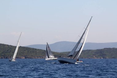 Bodrum, Hindi. 22 Mart 2019: Yelkenliler Ege Denizi 'nin mavi sularında, ünlü tatil beldesi Bodrum' un kıyılarında rüzgarlı havada yelken açıyorlar..