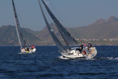 Bodrum, Hindi. 22 Mart 2019: Yelkenliler Ege Denizi 'nin mavi sularında, ünlü tatil beldesi Bodrum' un kıyılarında rüzgarlı havada yelken açıyorlar..