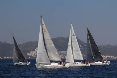 Bodrum, Hindi. 22 Mart 2019: Yelkenliler Ege Denizi 'nin mavi sularında, ünlü tatil beldesi Bodrum' un kıyılarında rüzgarlı havada yelken açıyorlar..
