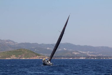 Bodrum, Hindi. 22 Mart 2019: Yelkenliler Ege Denizi 'nin mavi sularında, ünlü tatil beldesi Bodrum' un kıyılarında rüzgarlı havada yelken açıyorlar..