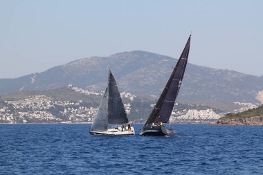 Bodrum, Hindi. 22 Mart 2019: Yelkenliler Ege Denizi 'nin mavi sularında, ünlü tatil beldesi Bodrum' un kıyılarında rüzgarlı havada yelken açıyorlar..