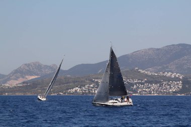 Bodrum, Hindi. 22 Mart 2019: Yelkenliler Ege Denizi 'nin mavi sularında, ünlü tatil beldesi Bodrum' un kıyılarında rüzgarlı havada yelken açıyorlar..