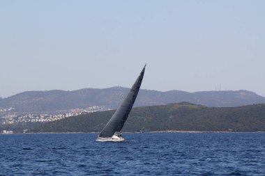 Bodrum, Hindi. 22 Mart 2019: Yelkenliler Ege Denizi 'nin mavi sularında, ünlü tatil beldesi Bodrum' un kıyılarında rüzgarlı havada yelken açıyorlar..