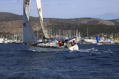 Bodrum, Hindi. 02 Aralık 2023: Yelkenliler Ege Denizi 'nin mavi sularında, ünlü tatil beldesi Bodrum' un kıyılarında rüzgarlı havada yelken açıyorlar..