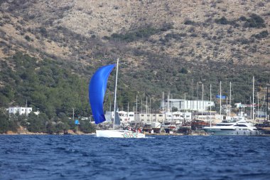 Bodrum, Hindi. 02 Aralık 2023: Yelkenliler Ege Denizi 'nin mavi sularında, ünlü tatil beldesi Bodrum' un kıyılarında rüzgarlı havada yelken açıyorlar..