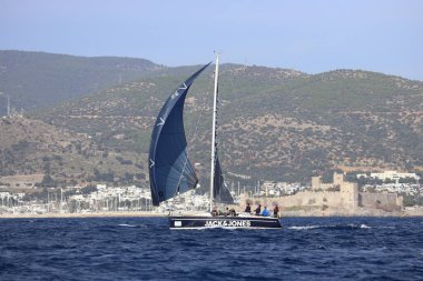 Bodrum, Hindi. 02 Aralık 2023: Yelkenliler Ege Denizi 'nin mavi sularında, ünlü tatil beldesi Bodrum' un kıyılarında rüzgarlı havada yelken açıyorlar..