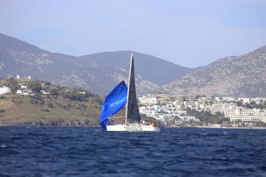 Bodrum, Hindi. 02 Aralık 2023: Yelkenliler Ege Denizi 'nin mavi sularında, ünlü tatil beldesi Bodrum' un kıyılarında rüzgarlı havada yelken açıyorlar..