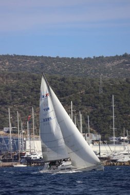 Bodrum, Hindi. 02 Aralık 2023: Yelkenliler Ege Denizi 'nin mavi sularında, ünlü tatil beldesi Bodrum' un kıyılarında rüzgarlı havada yelken açıyorlar..