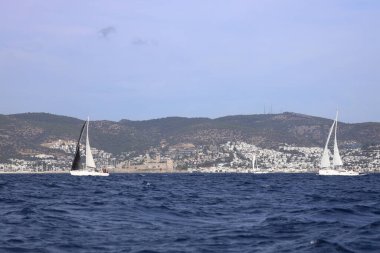 Bodrum, Hindi. 02 Aralık 2023: Yelkenliler Ege Denizi 'nin mavi sularında, ünlü tatil beldesi Bodrum' un kıyılarında rüzgarlı havada yelken açıyorlar..