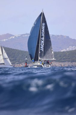 Bodrum, Hindi. 02 Aralık 2023: Yelkenliler Ege Denizi 'nin mavi sularında, ünlü tatil beldesi Bodrum' un kıyılarında rüzgarlı havada yelken açıyorlar..