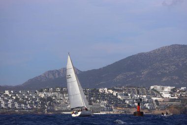 Bodrum, Hindi. 02 Aralık 2023: Yelkenliler Ege Denizi 'nin mavi sularında, ünlü tatil beldesi Bodrum' un kıyılarında rüzgarlı havada yelken açıyorlar..